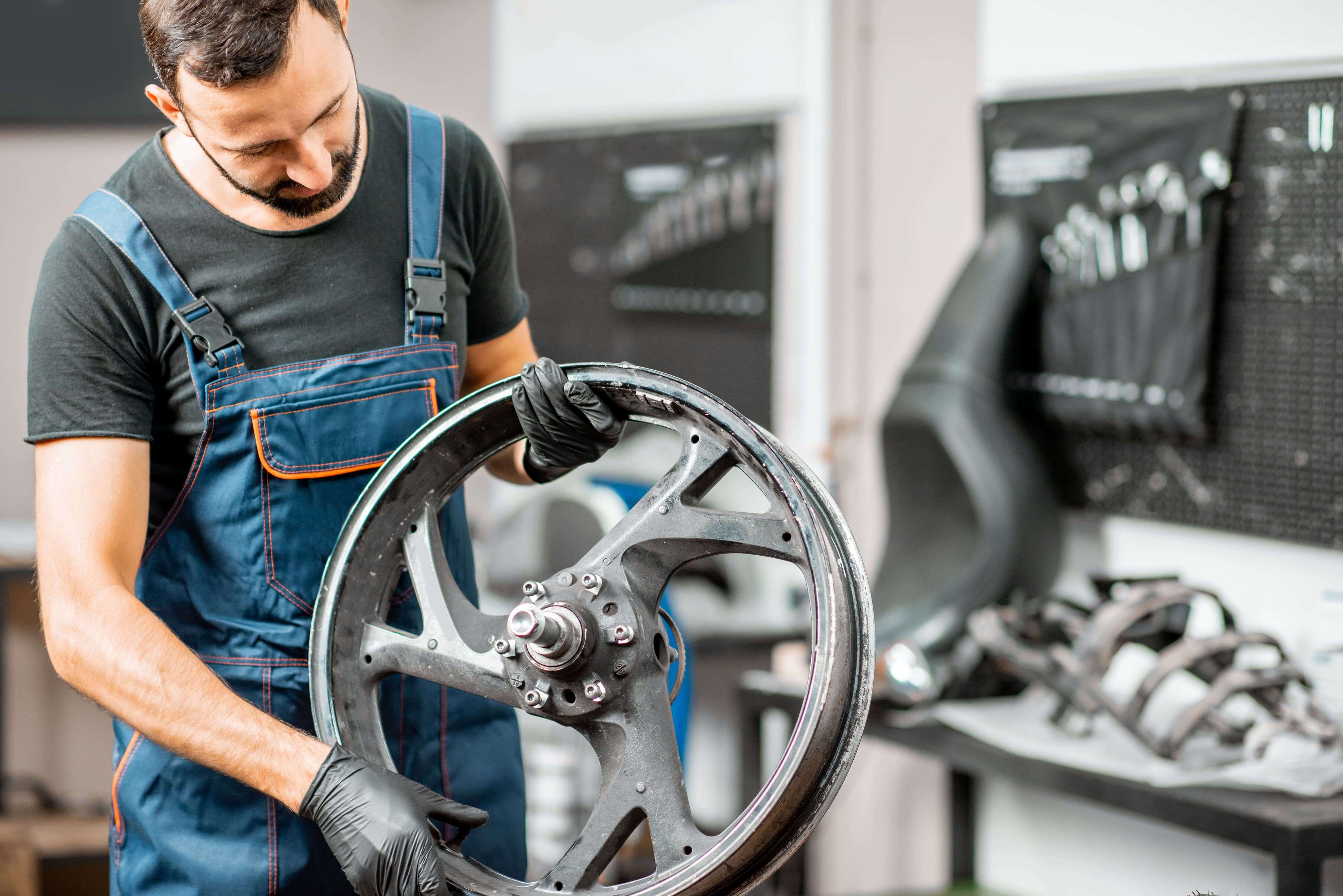 DIY rider changing a motorcycle tire in a home garage