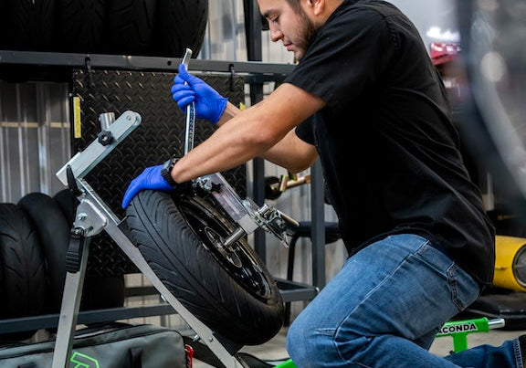 Technician changing a motorcycle tire with a Rabaconda tire changer