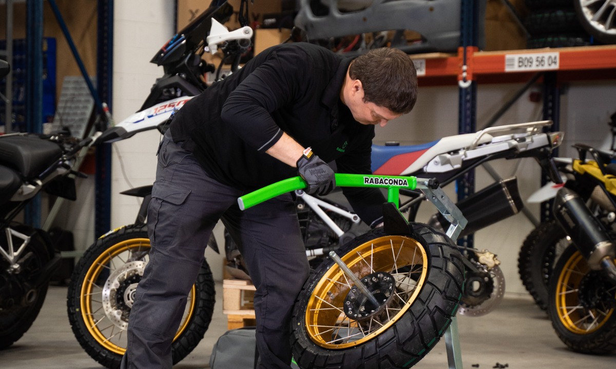 Street motorcycle tire bead breaker pressing down on the tire